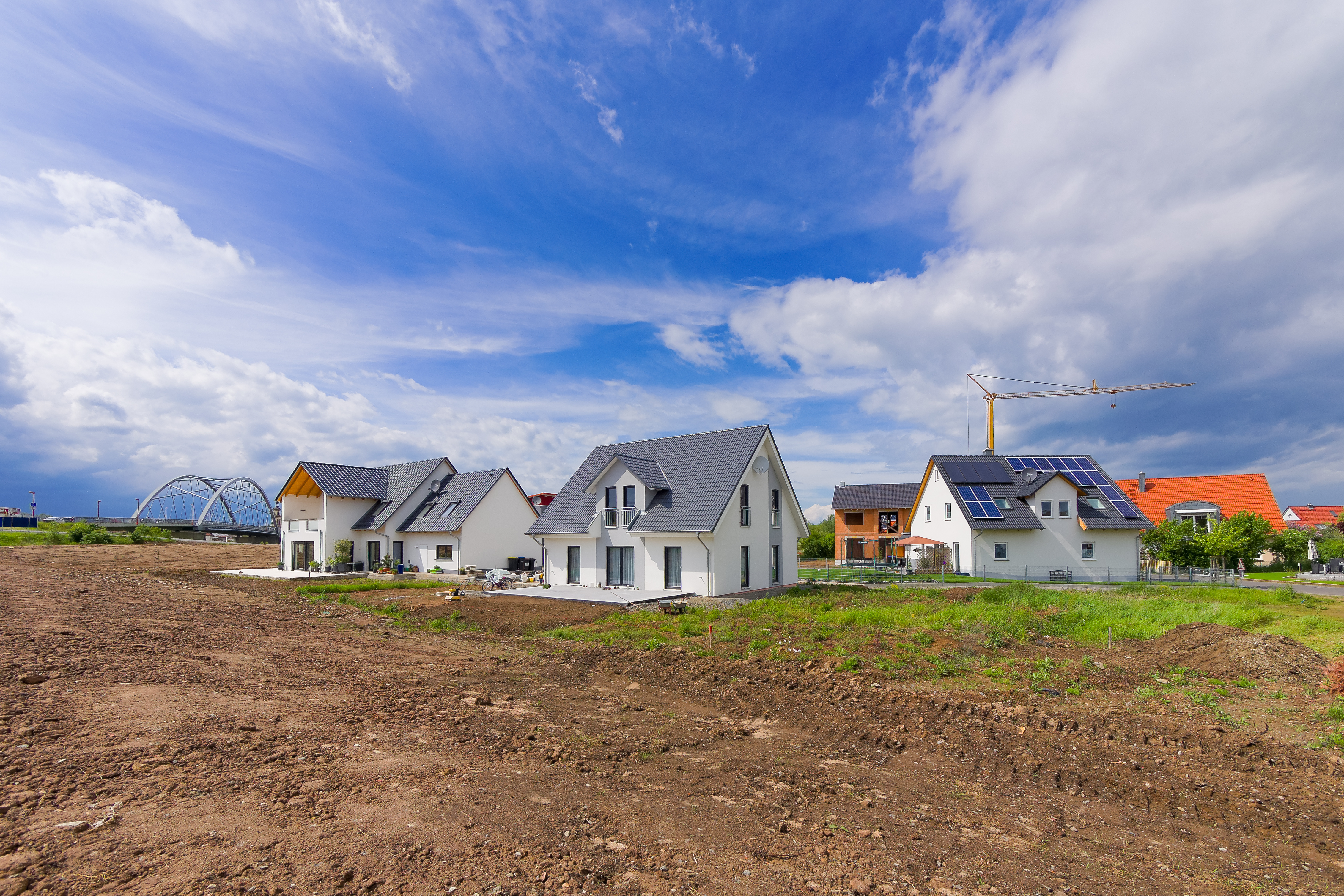 Neu gebaute Einfamilienhäuser vor blauem Himmel