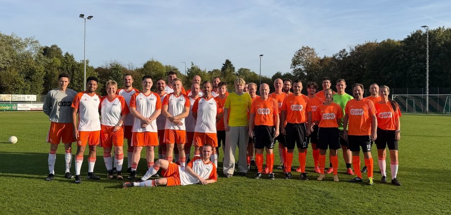 Gruppenfoto der Bürgermeister RLP und der evm-Gruppe auf dem Fußballplatz.