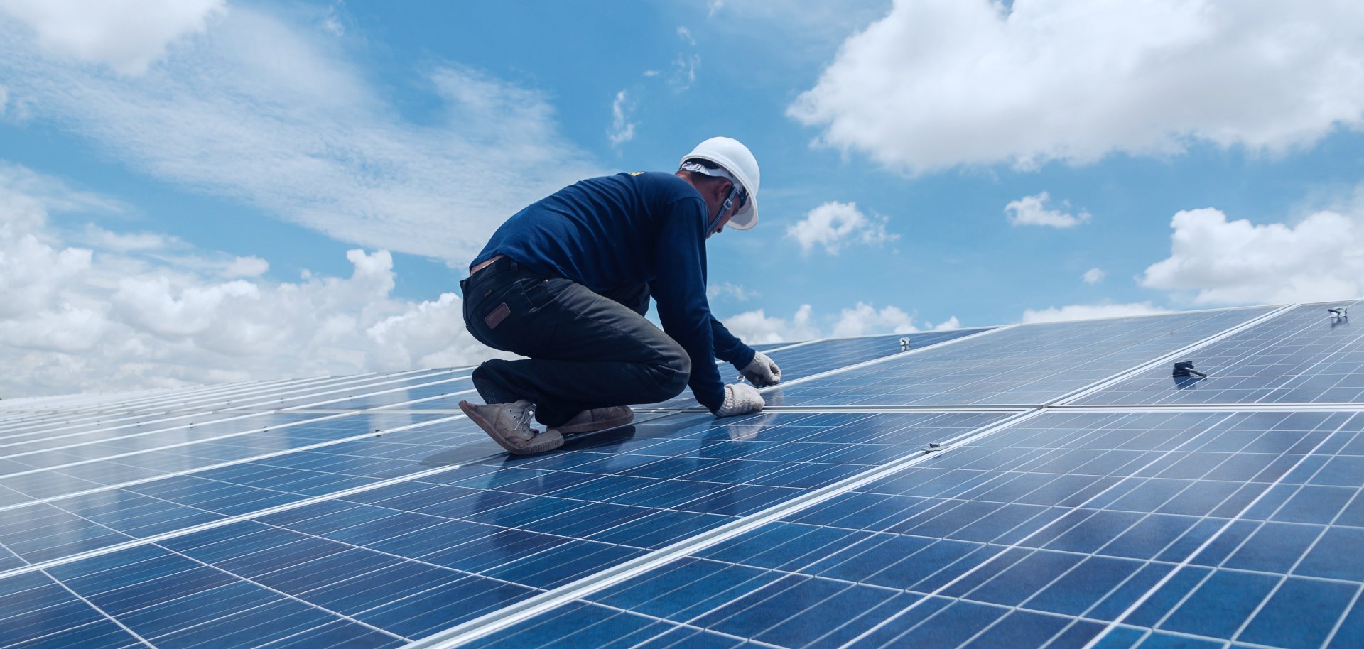 Handwerker montiert eine Solaranlage auf einem Dach.