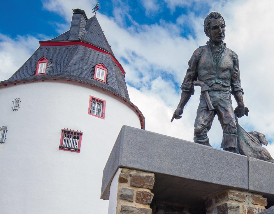 H.PIEL /Ein berühmter Sohn der Stadt: Der Räuber „Schinderhannes“ ist mit einem Denkmal vor dem nach ihm benannten Turm verewigt. Das Bauwerk dient als Veranstaltungsraum und ist Teil des Hunsrück-Museums.