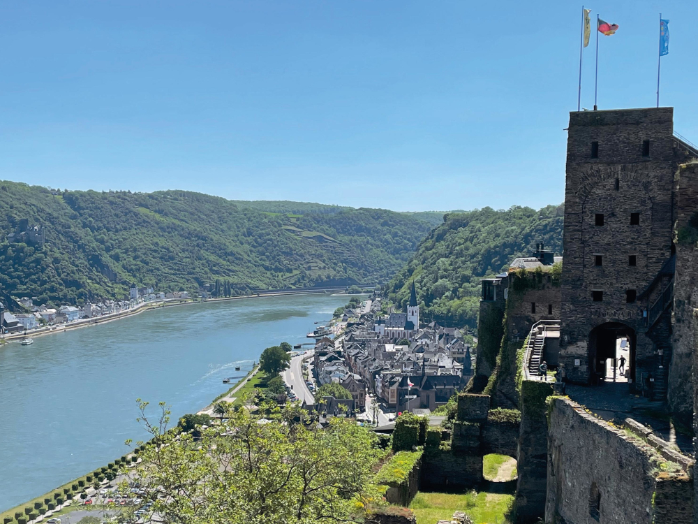 Imposanter Ausblick von der Burg Rheinfels aus hinunter auf die Stadt Sankt Goar, die Stiftskirche und den sich durch das UNESCO Welterbe Oberes Mittelrheintal schlängelnden Rhein.