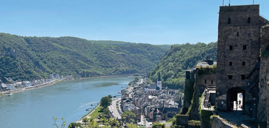 Imposanter Ausblick von der Burg Rheinfels aus hinunter auf die Stadt Sankt Goar, die Stiftskirche und den sich durch das UNESCO Welterbe Oberes Mittelrheintal schlängelnden Rhein.