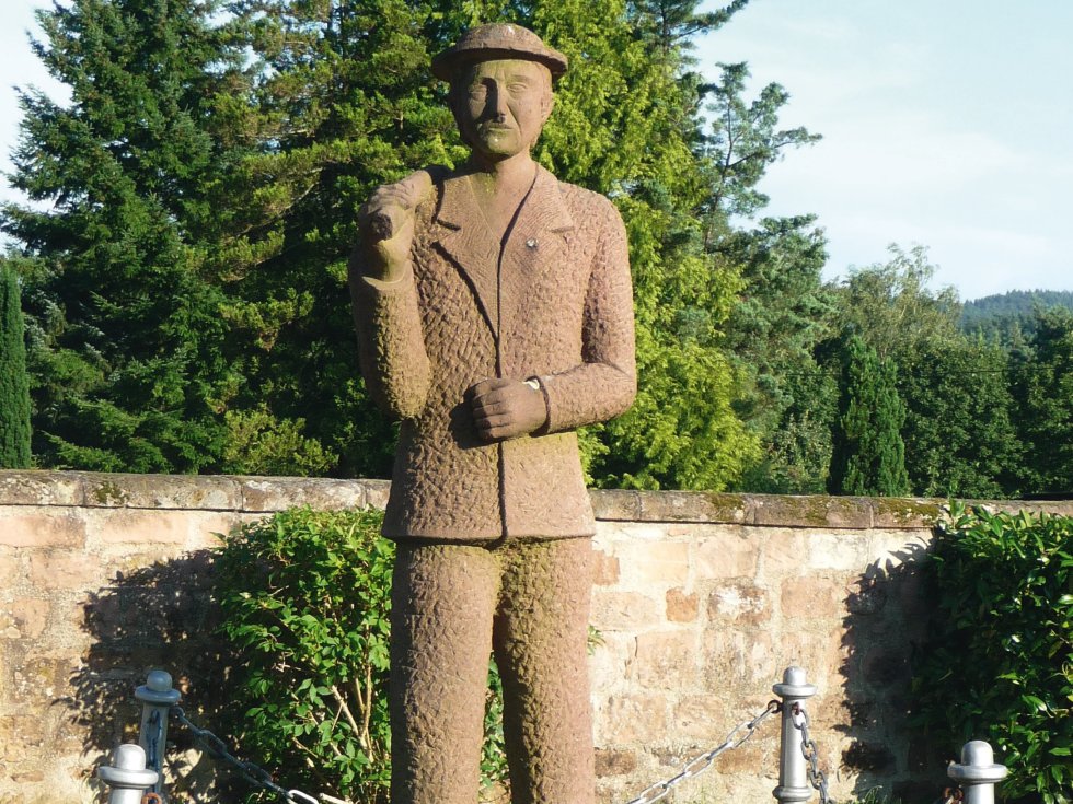Der „Handelsmann“ verweist auf die geschäftigen Ursprünge der Ortsgemeinde Carlsberg/Hertlingshausen. Sie entstand im 18. Jahrhundert aus einem Hof nebst Arbeitshütte, die ein regierender Graf Carl zu einer politischen Einheit zusammenfasste. Copy: Immanuel Giel, CC BY-SA 4.0