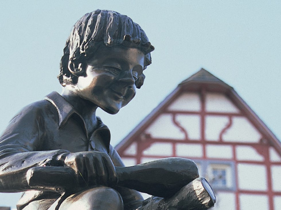 Das Treiser Wahrzeichen auf dem Marktplatz – die markante Brunnenfigur des „Heckedotz“. Das kleine Männlein auf der Spitze des Brunnens erinnert an die Vergangenheit des Dorfes. / Foto: Bruno L. Klamm, Mannheim