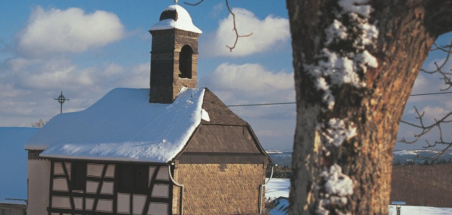 Das 1762 erbaute Glockenhaus prägt den Hattgensteiner Ortskern. Ursprünglich Wohnhaus des Gemeindedieners und Schulhaus, wird es seit 1975 als kleine Kirche genutzt. / Foto: Bruno L. Klamm, Mannheim