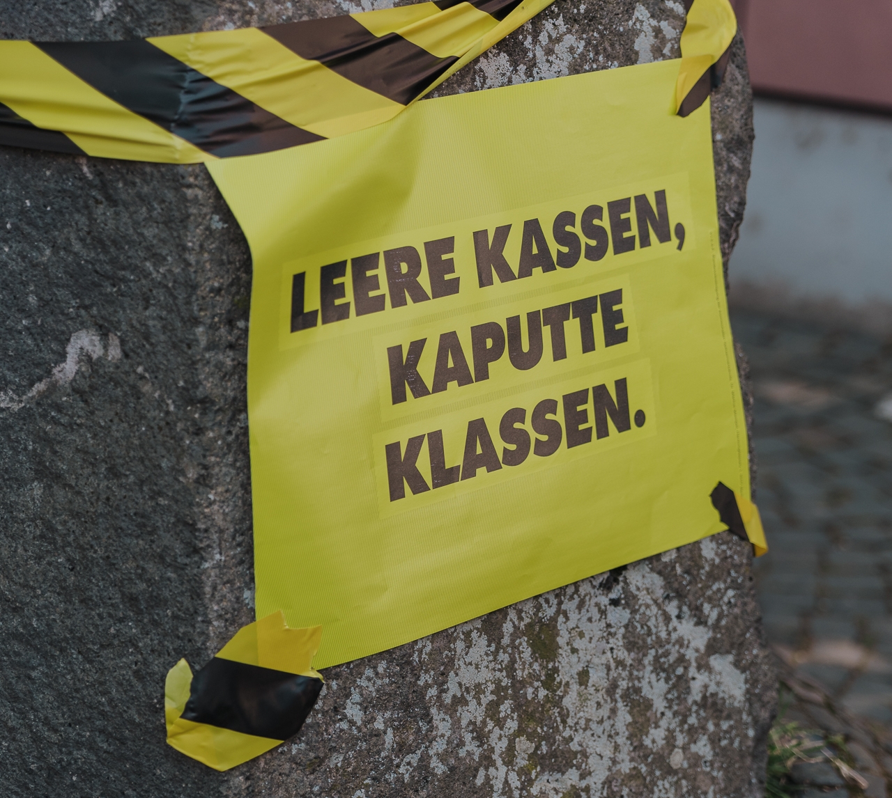 Gelbes Schild mit der Aufschrift "Leere Kassen, kaputte Klassen".