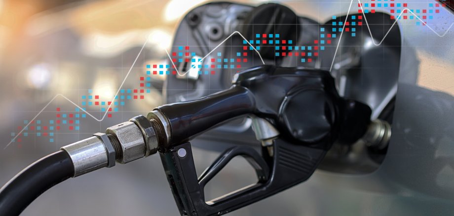 Schwarze Zapfpistole, die Benzin in Auto pumpt, symbolisiert die Energiekostenkrise.