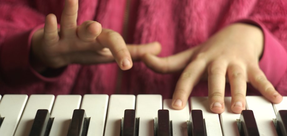 Kinderhände spielen Klavier.