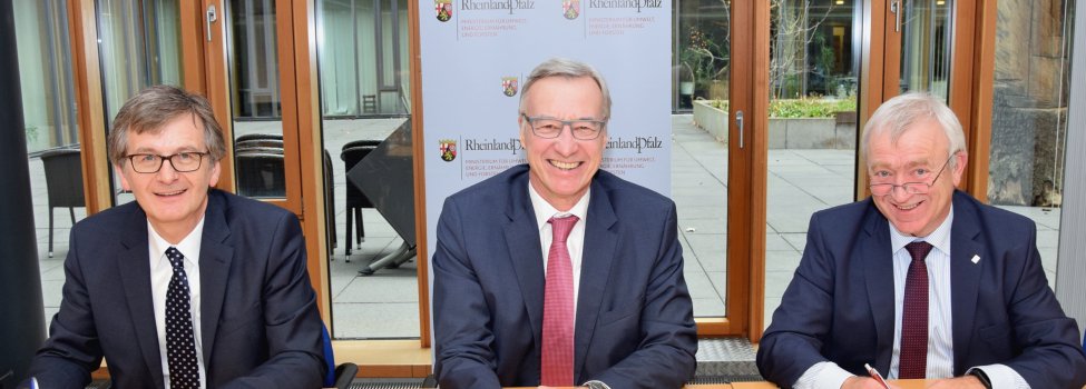 Forststaatssekretär Dr. Thomas Griese (Mitte), Hans-Günter Fischer, Vorsitzender des Waldbesitzerverbandes Rheinland-Pfalz (links) und Aloysius Söhngen, stellvertretender Vorsitzender des Gemeinde- und Städtebundes Rheinland-Pfalz (rechts), unterzeichnen das Gesamtkonzept. © MUEEF
