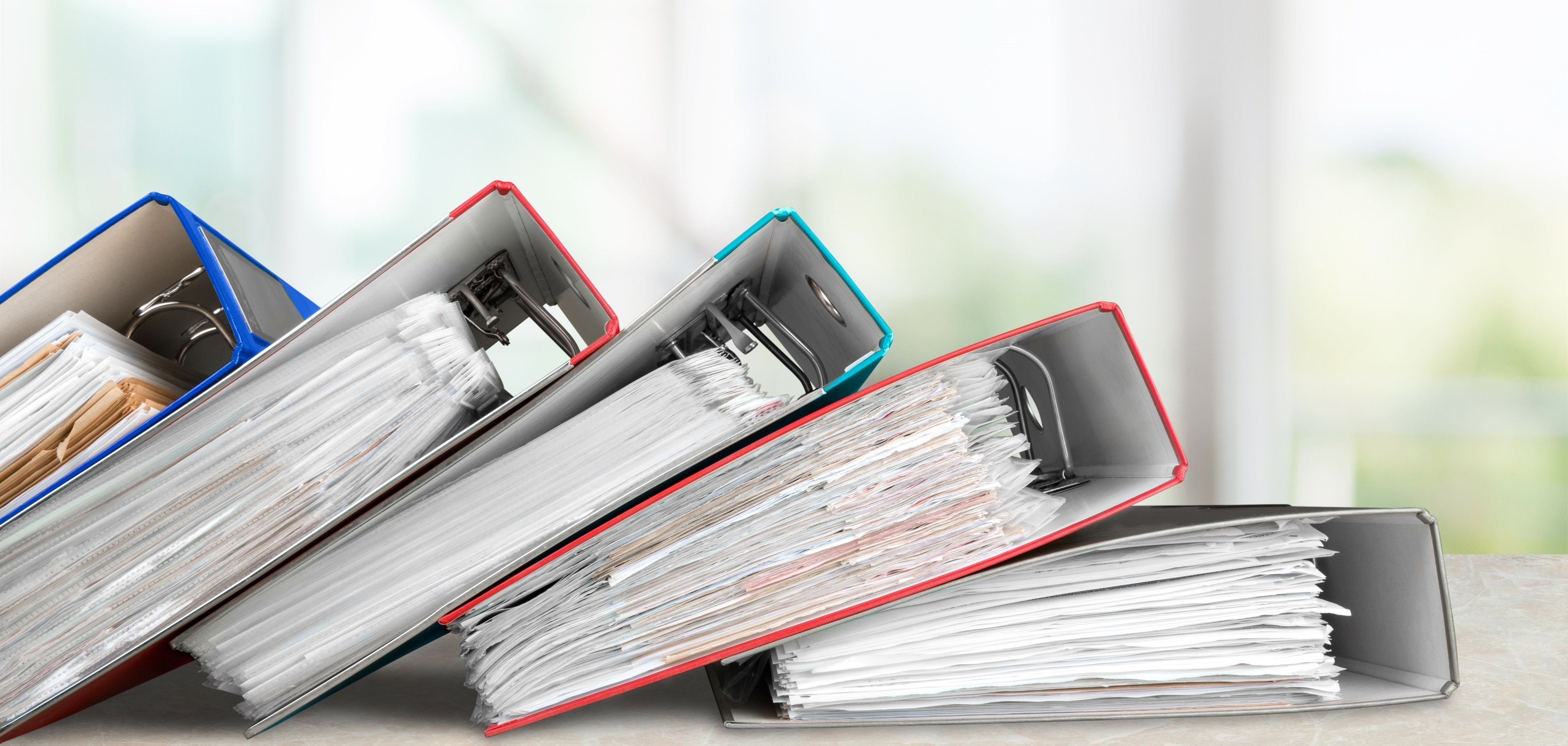 Das Bild zeigt Aktenordner mit Dokumenten. 