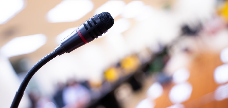 Nahaufnahme eines Rednerpults mit Mikrofon in einem Konferenzraum Nahaufnahme eines Rednerpults mit Mikrofon in einem Konferenzraum