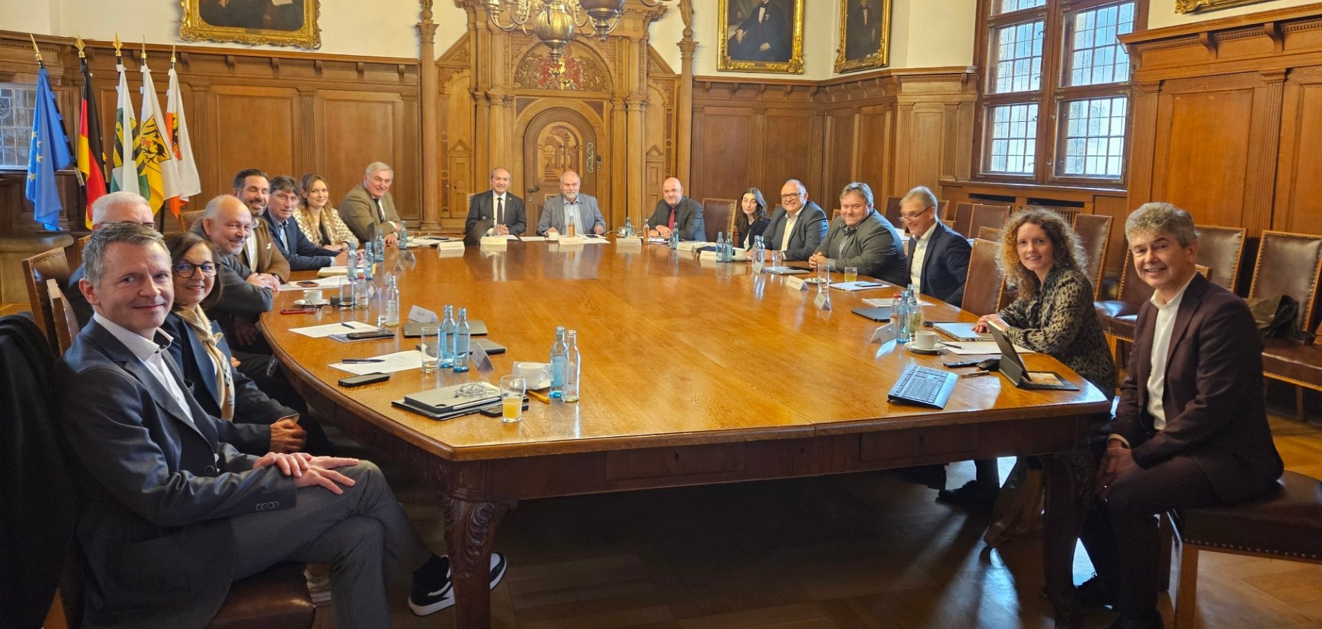 Die Mitglieder des Europaausschusses des Deutschen Städte- und Gemeindebundes  sitzen an einem großen Tisch in einem historischen Saal.