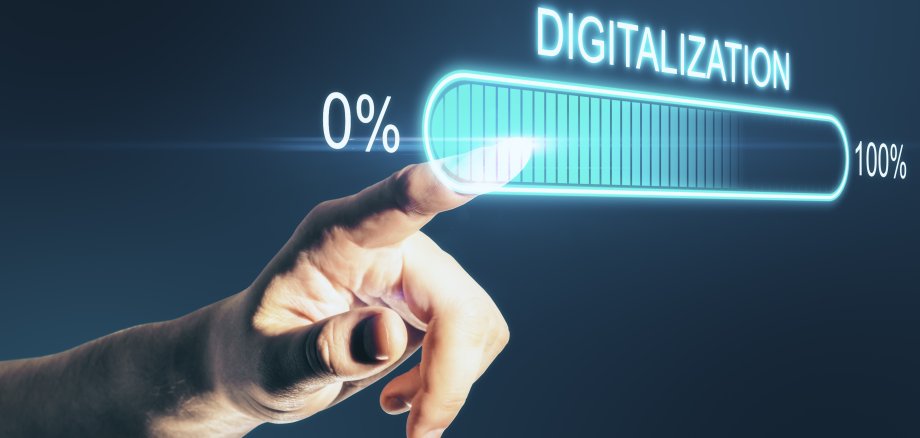 Finger zeigt auf virtuellen Ladebalken mit dem Wort "Digitalization".