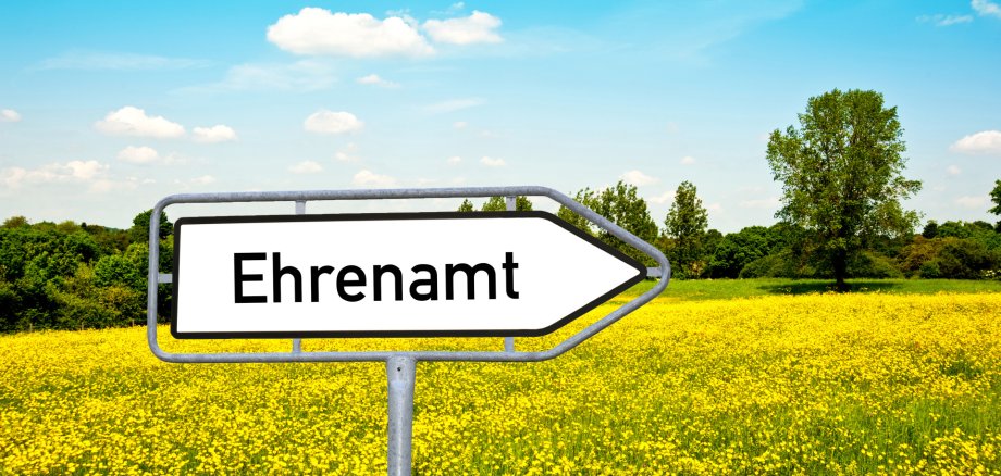 Ein Bild mit einem Wegweiser-Schild mit der Aufschrift "Ehrenamt"