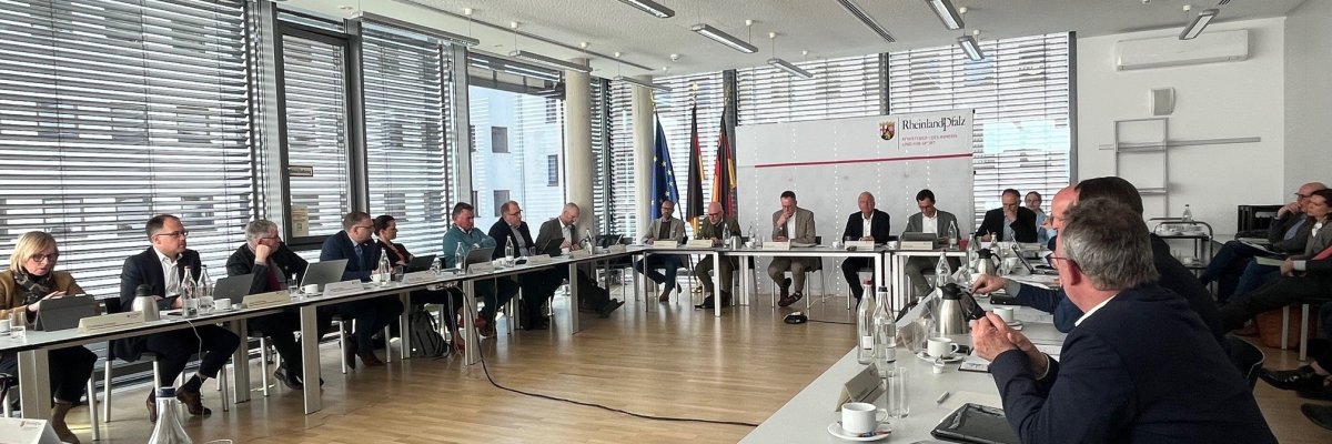 Mitglieder des Kommunalen Rates an Tischen in einem Sitzungssaal.