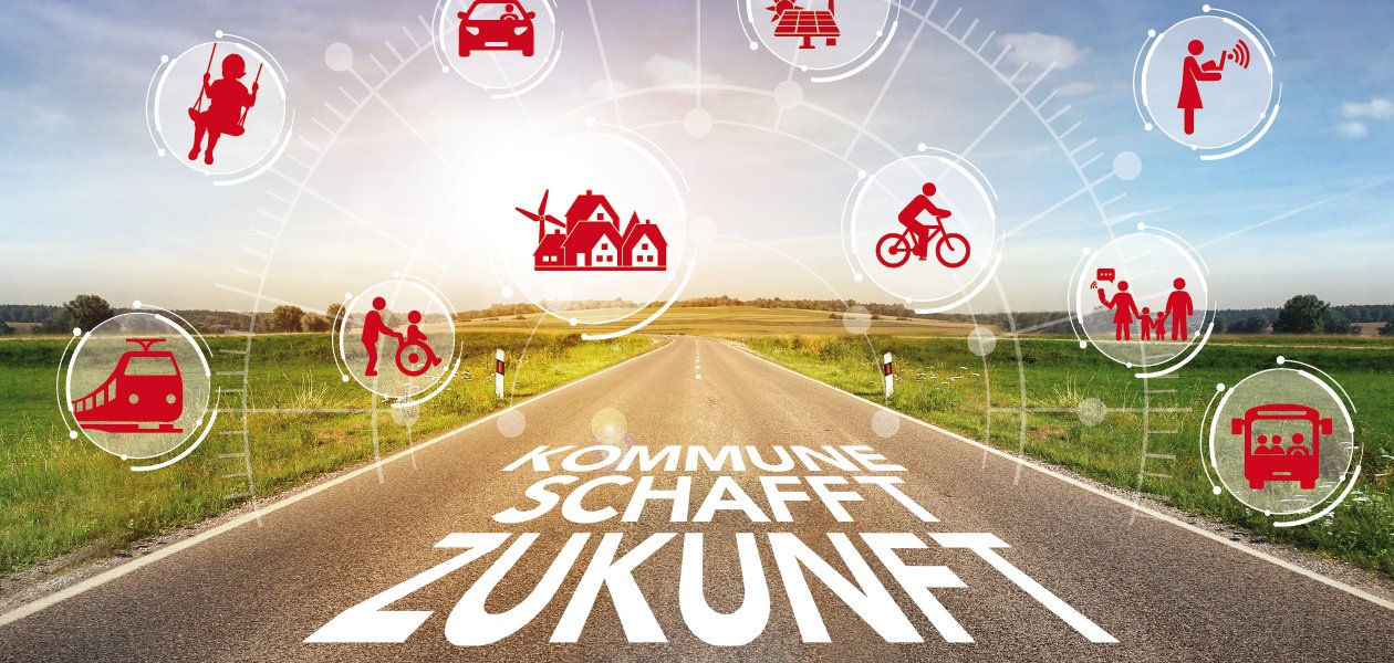 Straße mit der Aufschrift "Kommune schafft Zukunft". Die Straße ist umgeben von grüner Landschaft. Über ihr schweben rote Icons zum Thema Zukunft.