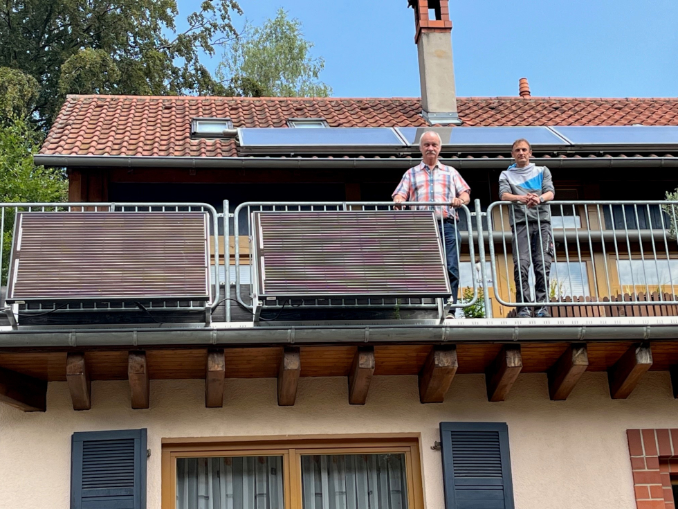 Ortsbürgermeister Michael Zimmermann (links) und Elektromeister Daniel Meyerer freuen sich über die zahlreichen neu installierten Balkonkraftwerke, wie bei Familie Merz in Hauenstein.