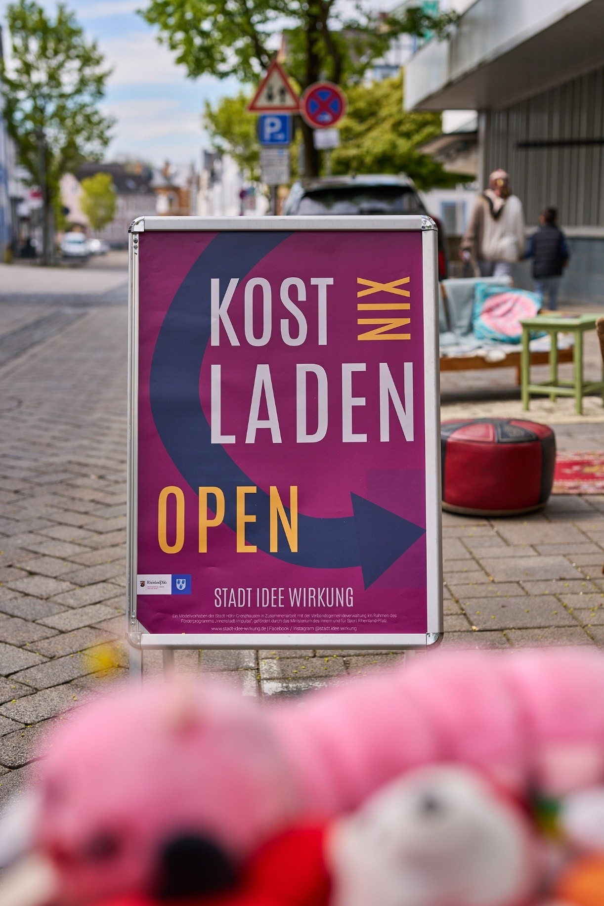 Aufsteller an der Straße macht auf den KostNixLaden aufmerksam.